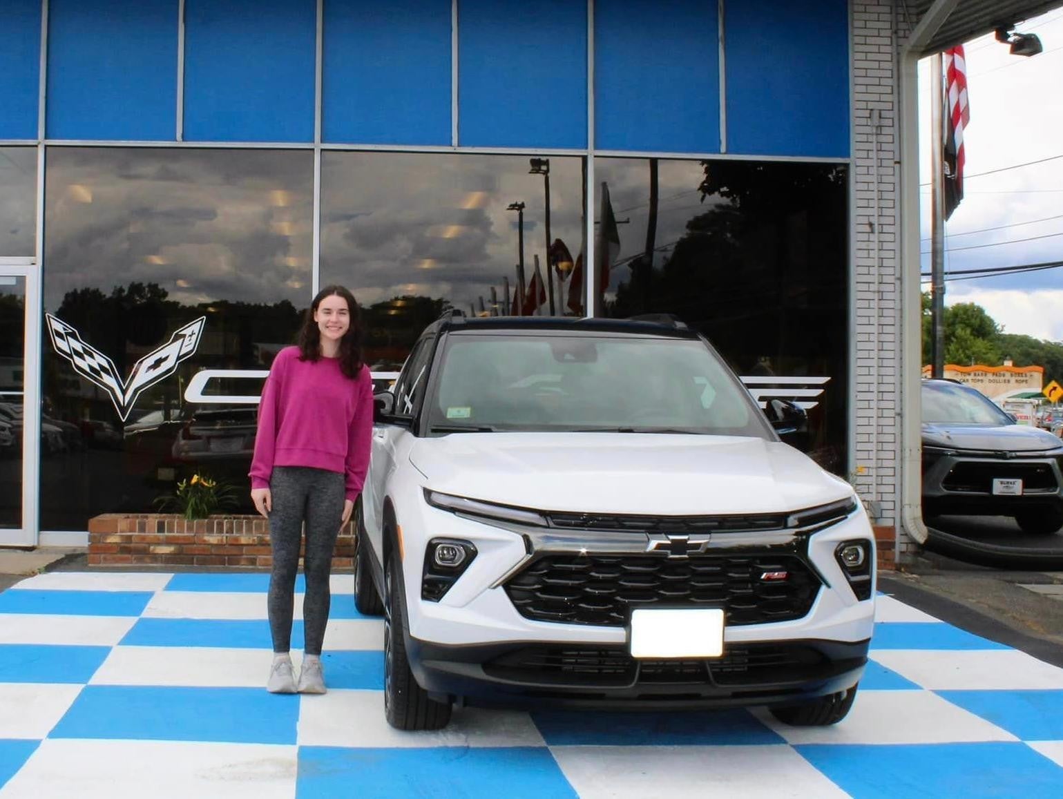 Women_standing_beside_a_White_chevrolet_vehicle