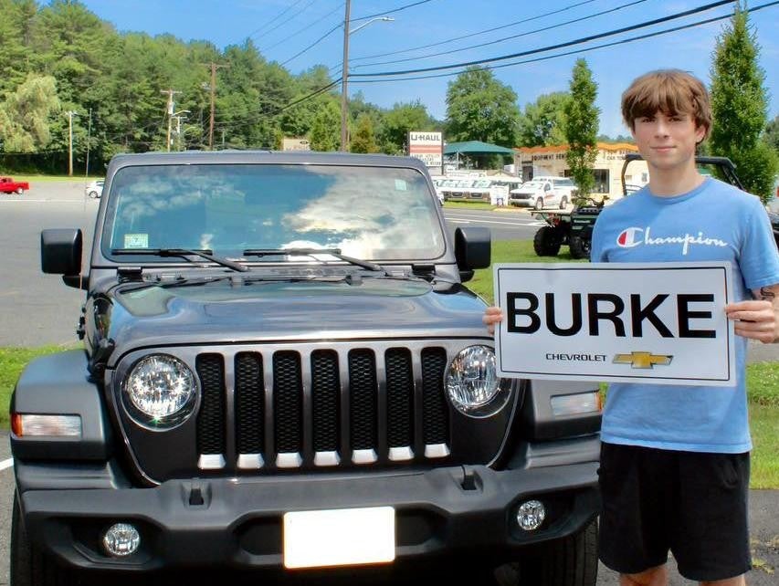 a_younger-boy-customer-holding-small-copy-burke-chevrolet-with-chevrolet-suv